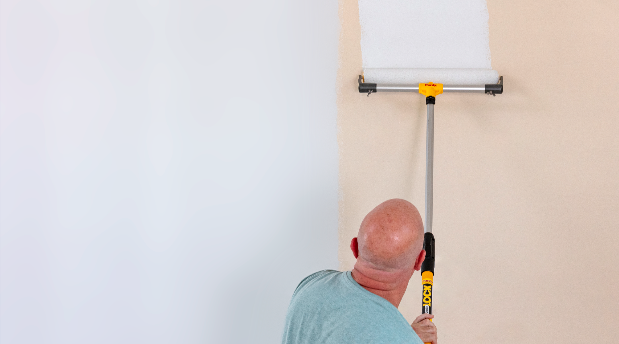 Pintor profesional cubriendo una pared grande con un rodillo de dieciocho pulgadas