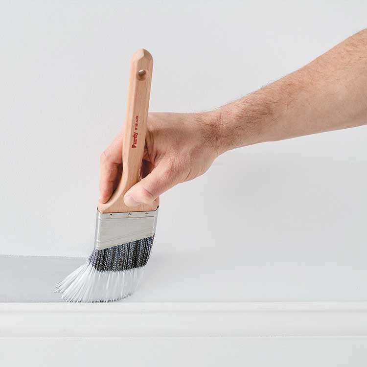 Purdy Spirex brush painting above a baseboard.