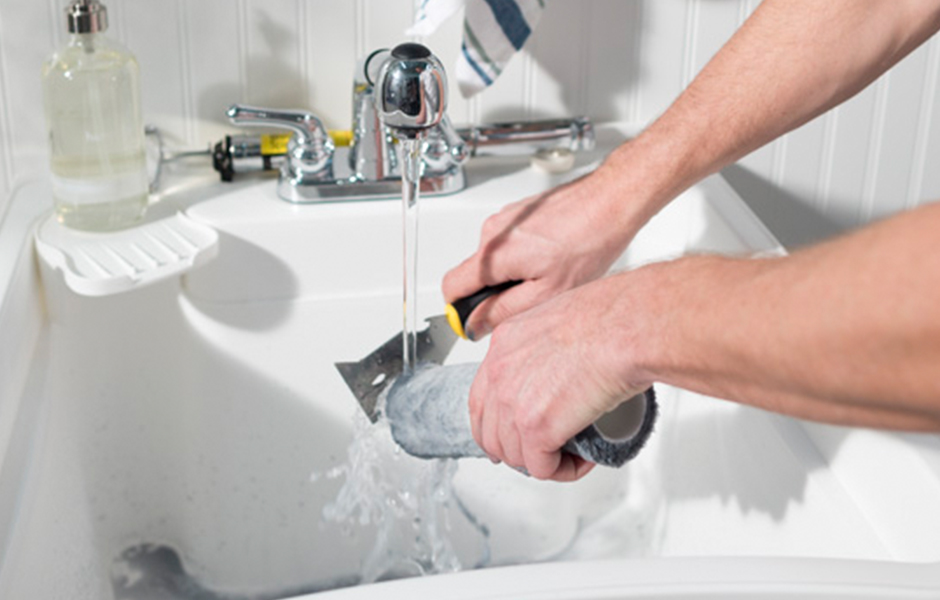 painter cleaning a roller in sink