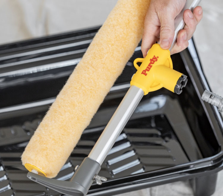 Pro painter attaching a large roller frame to an extension pole