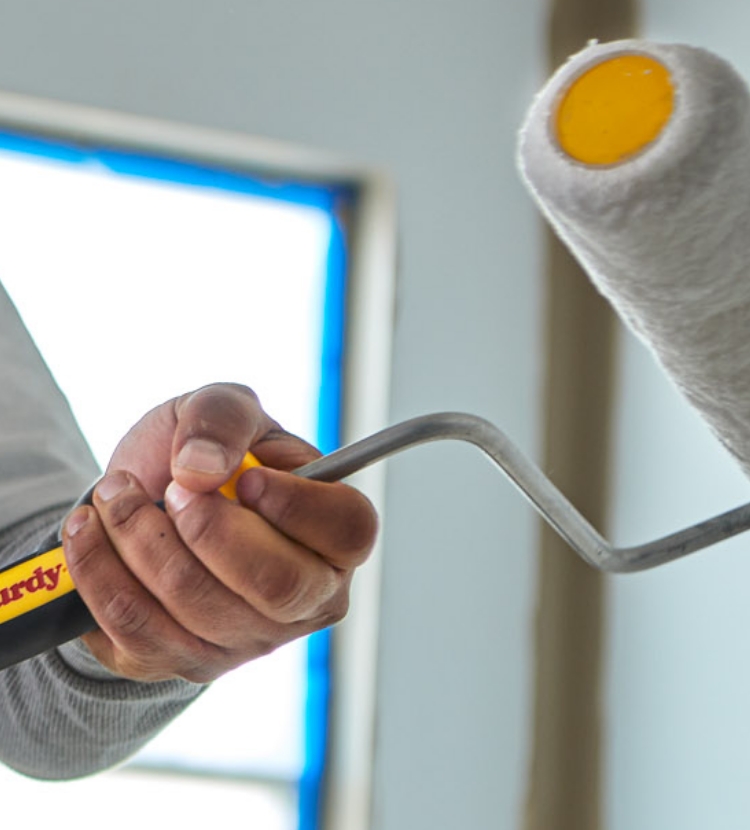 Pro painter attaching a nine-inch roller frame to an extension pole.