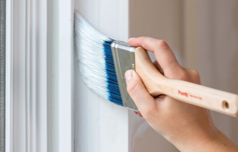 Pintor profesional pintando alrededor del marco de una puerta