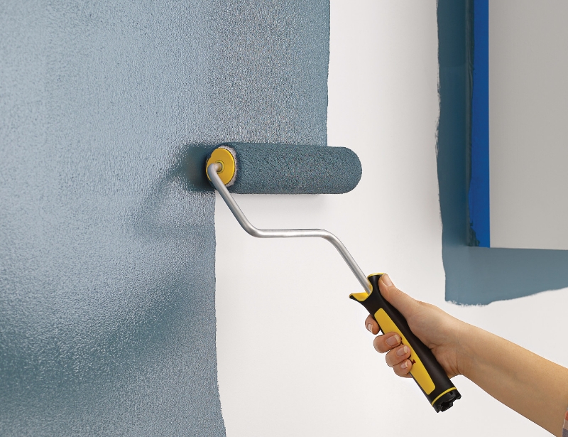 Pro painting a wall with a Purdy roller