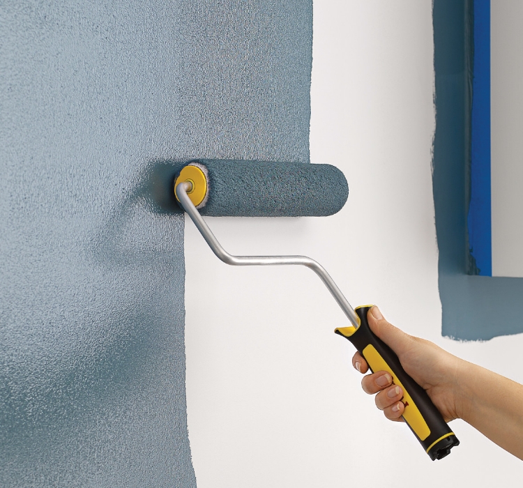 Pro painting a wall with a Purdy roller