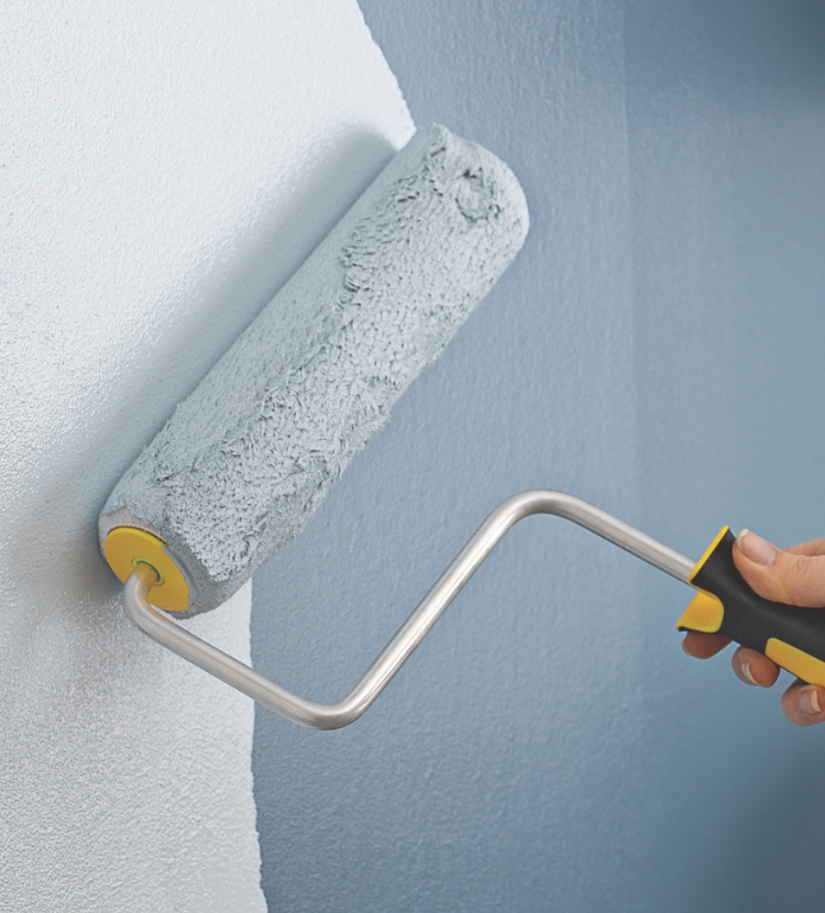 Pro painting a wall with a Purdy roller
