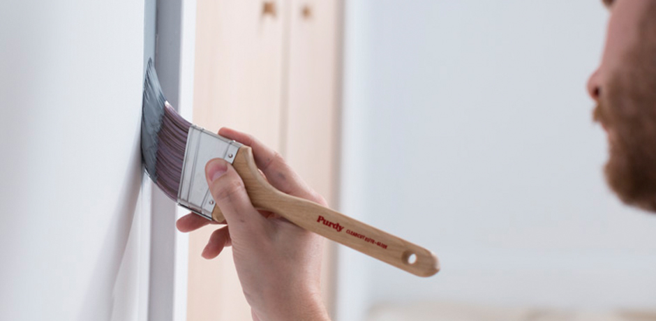 Pro painter cutting in around a door frame