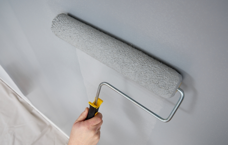 Rolling paint onto a smooth wall with an eighteen-inch roller.