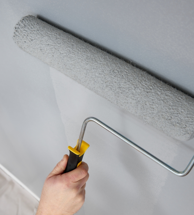 Rolling paint onto a smooth wall with an eighteen-inch roller.