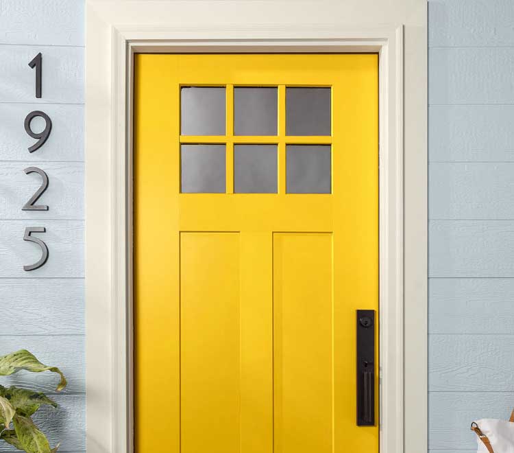 Modern front door painted bright yellow color with white trim.