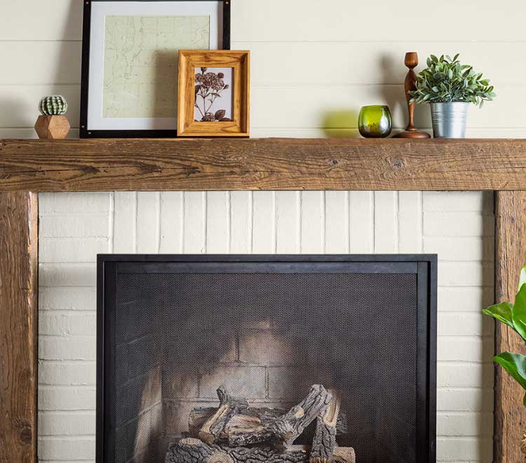 Beautiful painted white brick fireplace with a rustic wood mantle.