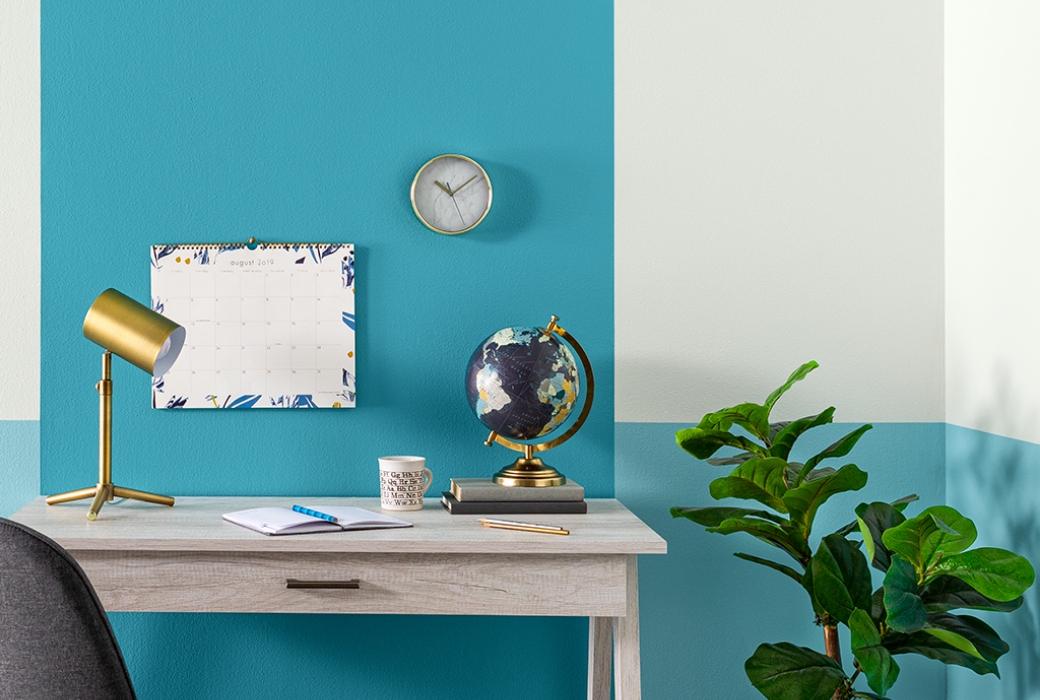 Close up view of the finished project, desk with books, a coffee cup, a globe and office supplies.