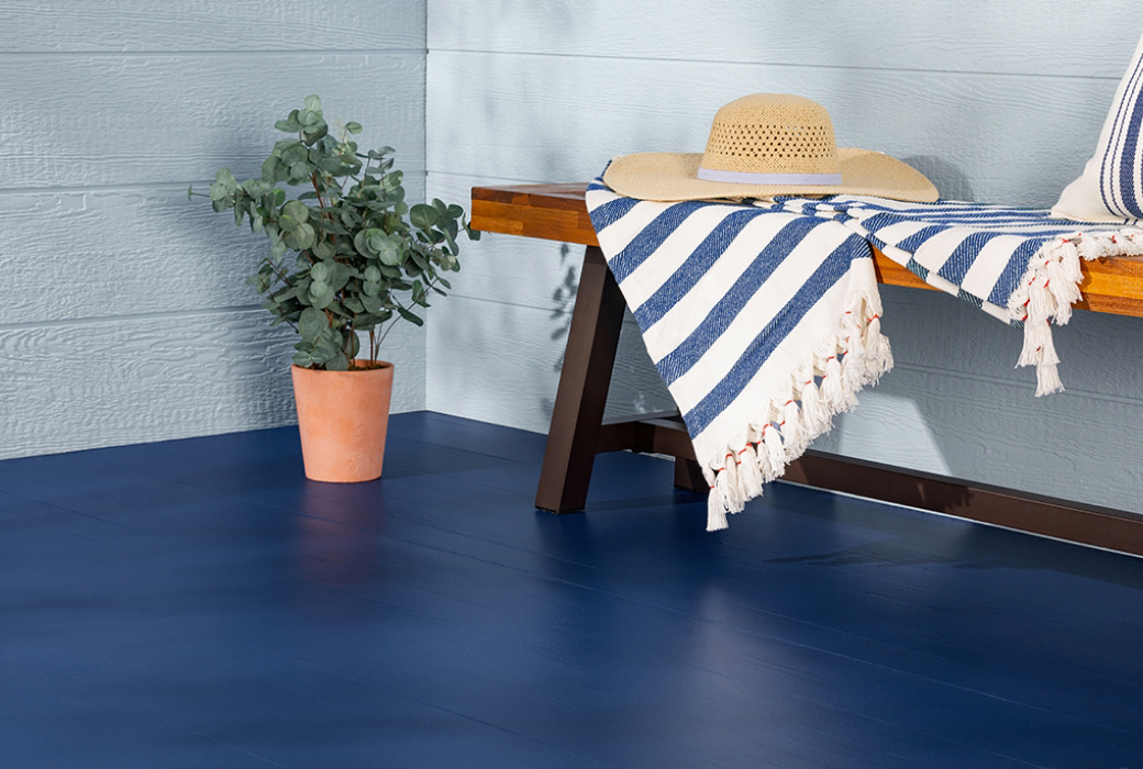 Detail of the finished stenciled floor with a white cabinet and a straw basket.