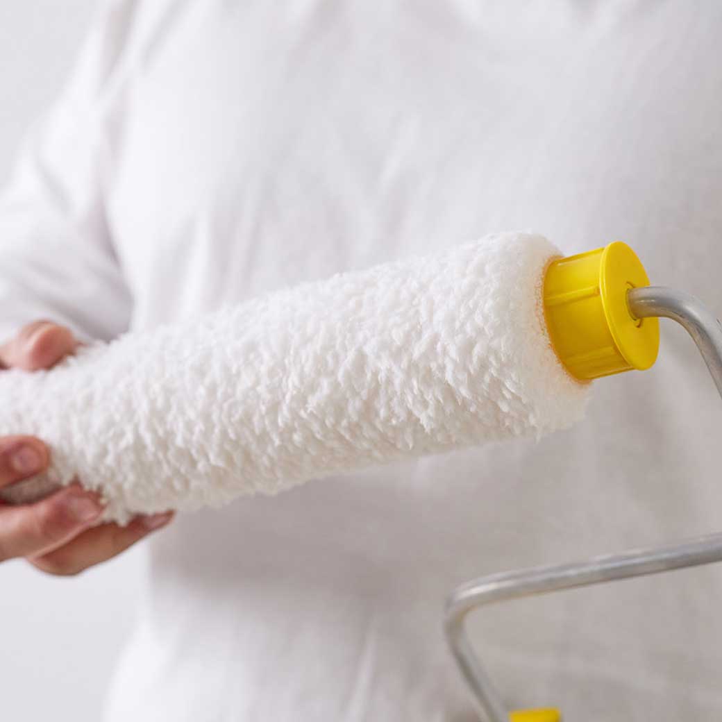 person installing a roller onto a roller frame
