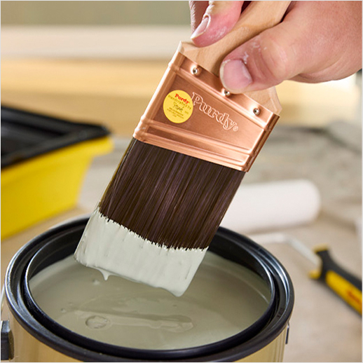 Dipping a Purdy brush into paint.