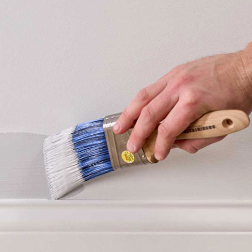 using a Purdy Pro-Extra® High Capacity brush to apply paint to a wall