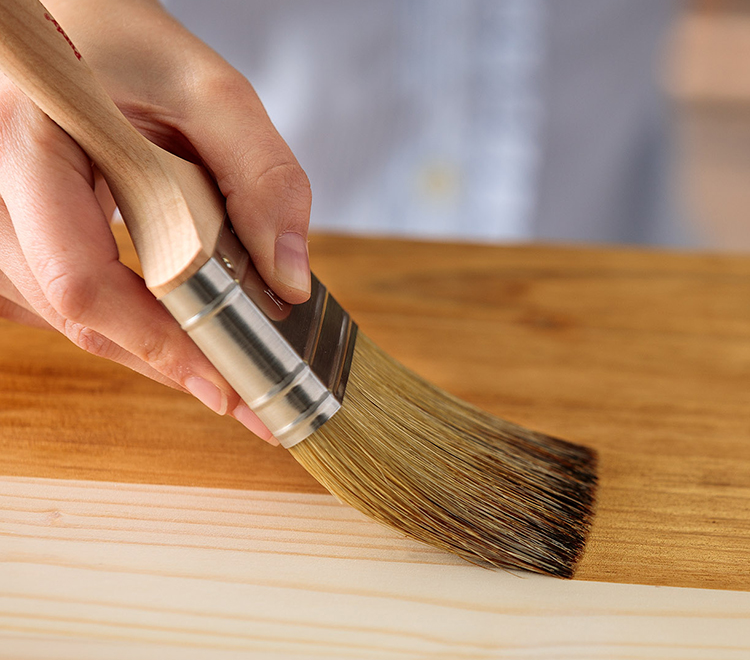 Purdy brush applying stain to wood