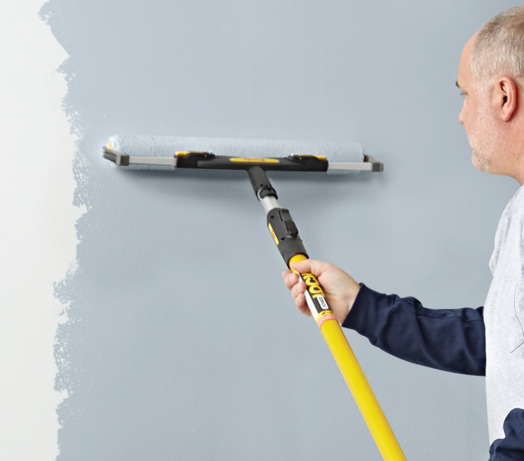 painter using Purdy roller to paint a wall