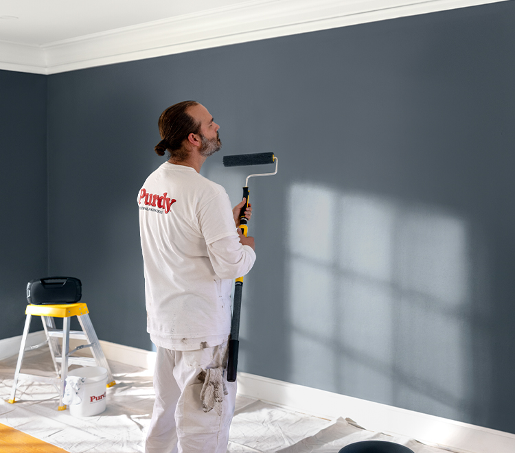 painter using Purdy roller to paint a wall